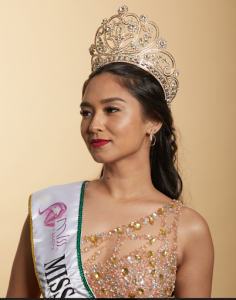Miss Nikkey 2022 em perfil, usando coroa e brincos delicados Julio Okubo