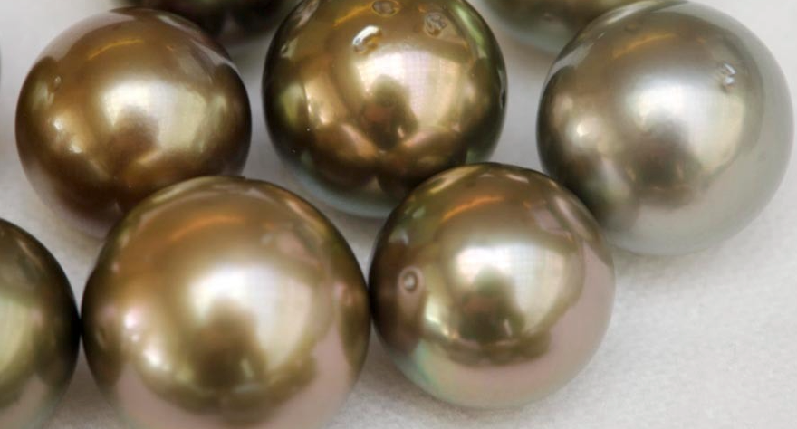 Pérolas com superfície iridescente em tons dourados e prateados